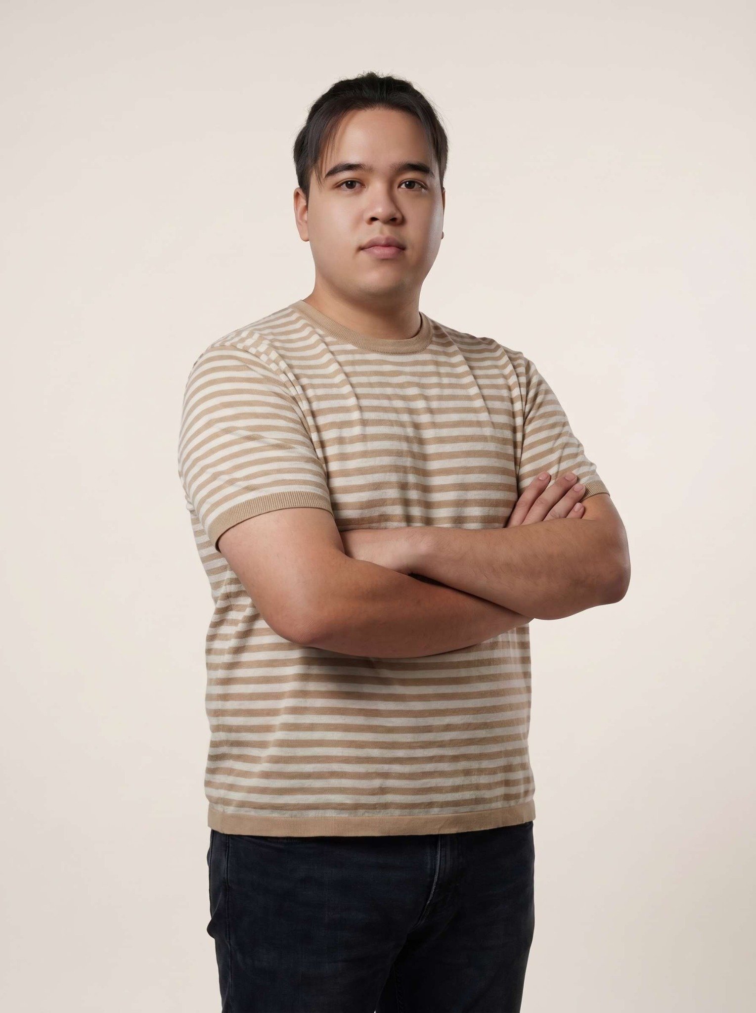 Boonyakorn Khanthong, founder of PixelNest, in a warm studio portrait with arms folded